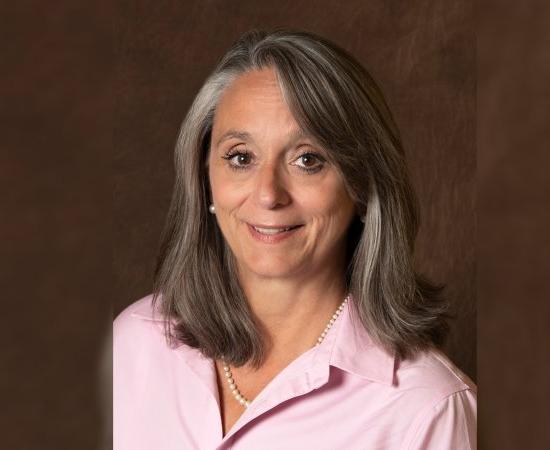 Patricia “Patty” Montone Charvat 'in a pink shirt smiles at the camera.